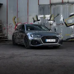 Szary Audi RS4 Avant na tle zniszczonej ściany z graffiti. Sprawdź aktualną audi rs4 cena.