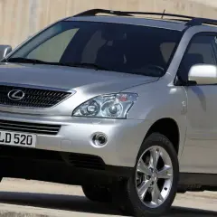 Srebrny Lexus RX 400h z przyciemnianymi szybami i relingami dachowymi, zaparkowany na betonowym podłożu.