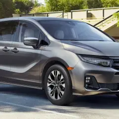 Elegancka, szara Honda Odyssey, model hybryda, zaparkowana na zewnątrz.