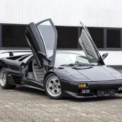 Czarny Lamborghini Diablo z otwartymi drzwiami, klasyk, którego lamborghini diablo cena budzi podziw.