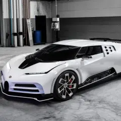 Biały Bugatti Centodieci z czarnym pasem na masce, stojący w garażu. Jego cena jest astronomiczna, ale to dzieło sztuki motoryzacyjnej.