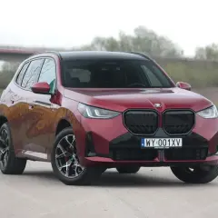 Czerwone BMW X3 30e z czarnymi dodatkami i felgami stoi na drodze.