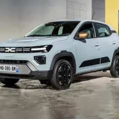Nowa Dacia Spring w jasnoszarym kolorze, z czarnymi akcentami i miedzianymi lusterkami, prezentuje się nowocześnie.