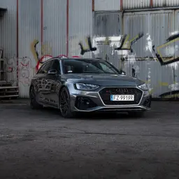 Szary Audi RS4 Avant na tle zniszczonej ściany z graffiti. Sprawdź aktualną audi rs4 cena.