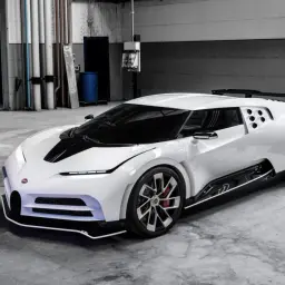 Biały Bugatti Centodieci z czarnym pasem na masce, stojący w garażu. Jego cena jest astronomiczna, ale to dzieło sztuki motoryzacyjnej.
