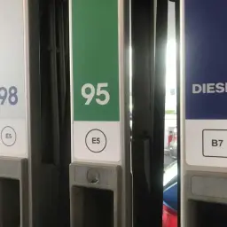 Kolumna z oznaczeniem diesla na stacji paliw, obok dystrybutorów 98 i 95.