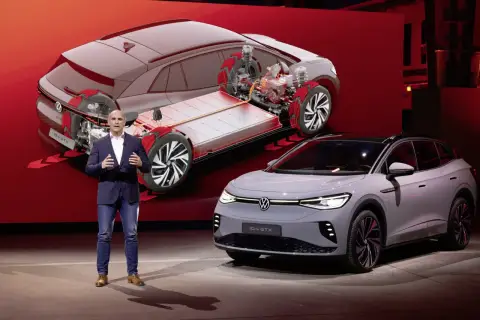 Mężczyzna prezentuje nowy model Volkswagen ID.4 GTX, pokazując jego elektryczny napęd i baterię.