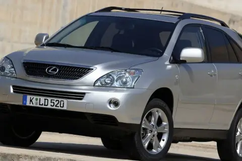 Srebrny Lexus RX 400h z przyciemnianymi szybami i relingami dachowymi, zaparkowany na betonowym podłożu.