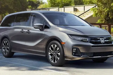Elegancka, szara Honda Odyssey, model hybryda, zaparkowana na zewnątrz.