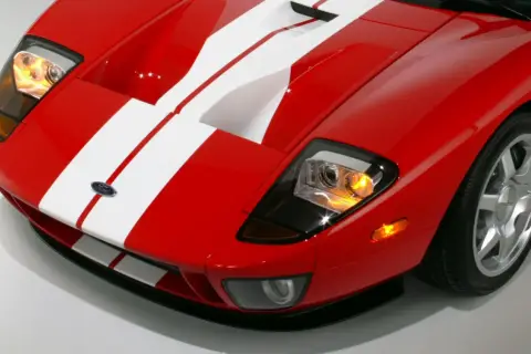 Czerwony Ford GT z białymi pasami, sportowy wygląd. Zastanawiasz się nad ford gt cena?