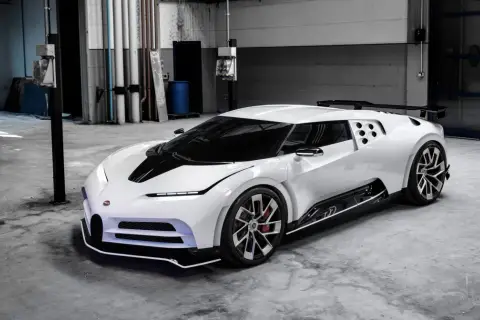 Biały Bugatti Centodieci z czarnym pasem na masce, stojący w garażu. Jego cena jest astronomiczna, ale to dzieło sztuki motoryzacyjnej.
