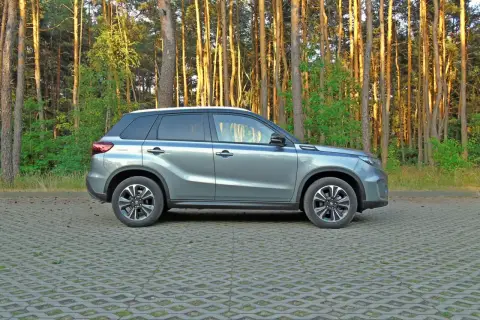 Szary Suzuki Vitara na tle lasu. Sprawdź atrakcyjną suzuki vitara cena i wybierz swój wymarzony model.