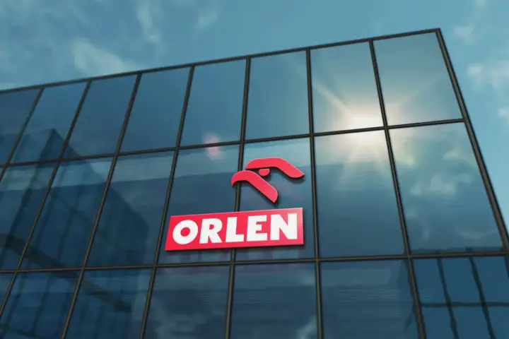 Logo ORLEN na szklanym budynku, symbolizujące najlepsze inwestycje.