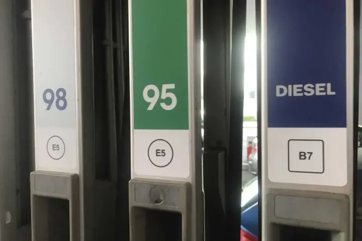 Kolumna z oznaczeniem diesla na stacji paliw, obok dystrybutorów 98 i 95.