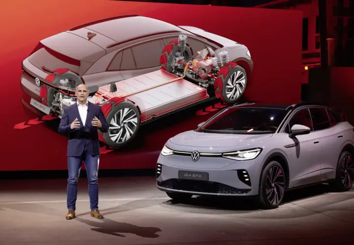 Mężczyzna prezentuje nowy model Volkswagen ID.4 GTX, pokazując jego elektryczny napęd i baterię.