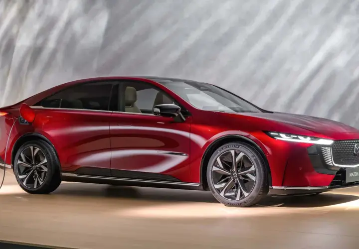 Czerwona Mazda 6e, ładowana elektrycznie, prezentuje nowoczesny design z eleganckimi liniami i dynamicznym profilem.