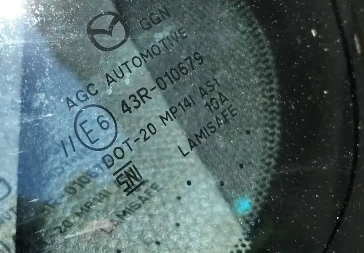 Widoczne oznaczenia na szybach samochodowych: AGC AUTOMOTIVE, E6, 43R-010679, DOT-20, LAMISAFE.
