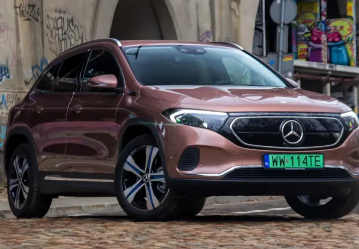 Różowy Mercedes EQA na tle graffiti.