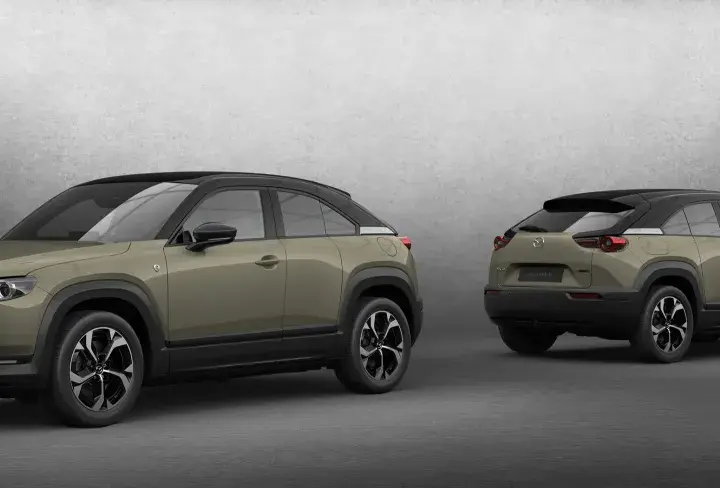 Dwa samochody Mazda MX-30 w kolorze oliwkowym z czarnym dachem, prezentowane z przodu i z tyłu.