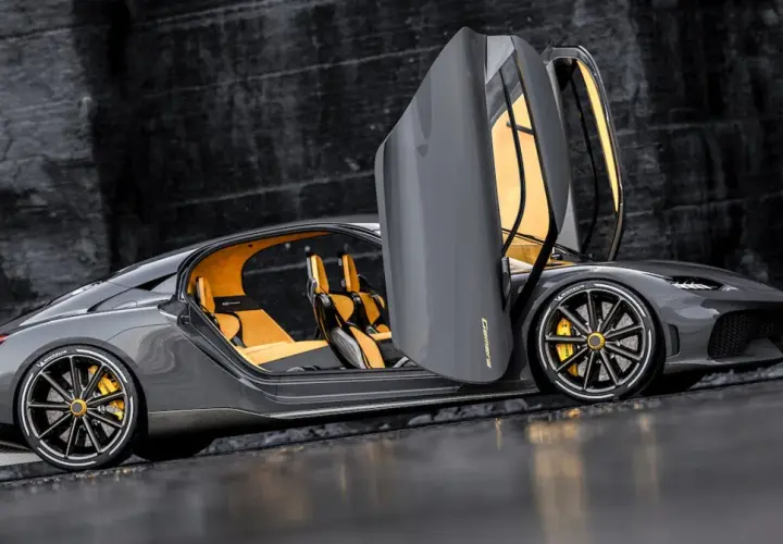 Szary Koenigsegg Gemera z otwartymi drzwiami i żółtym wnętrzem. Poznaj Koenigsegg Gemera cena i możliwości tego cudu techniki.