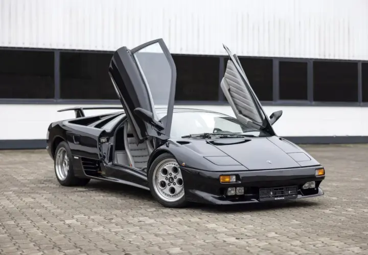Czarny Lamborghini Diablo z otwartymi drzwiami, klasyk, którego lamborghini diablo cena budzi podziw.