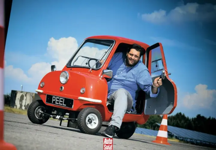 Uśmiechnięty mężczyzna w czerwonym Peel P50. Czy to najtańszy samochód świata?