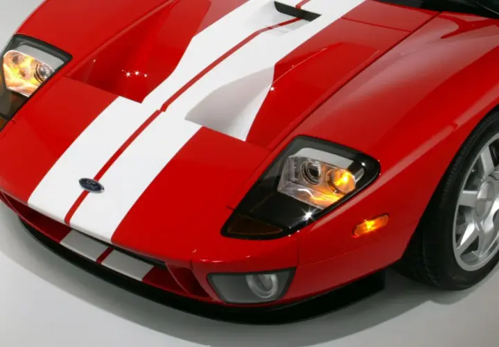 Czerwony Ford GT z białymi pasami, sportowy wygląd. Zastanawiasz się nad ford gt cena?