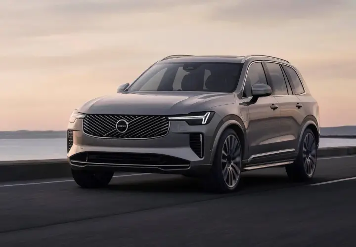 Szary Volvo XC90 jedzie po drodze nad morzem. Sprawdź aktualną volvo xc90 cena.