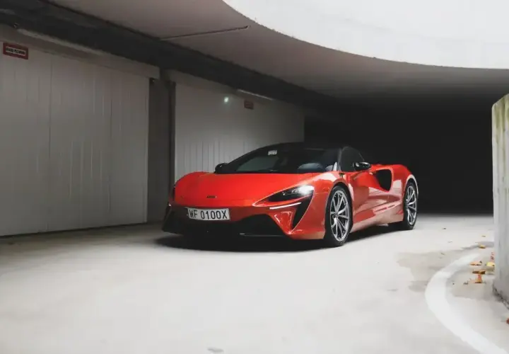 Czerwony McLaren w garażu, jego cena jest wysoka, ale wygląd zachwyca.