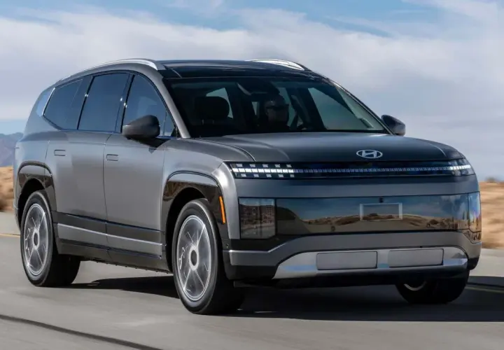 Szary Hyundai Ioniq 9 jedzie po pustynnej drodze. Futurystyczny design z charakterystycznymi światłami.