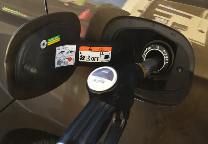 Tankowanie samochodu. Dystrybutor z napisem "diesel" wlewa olej napędowy do baku.
