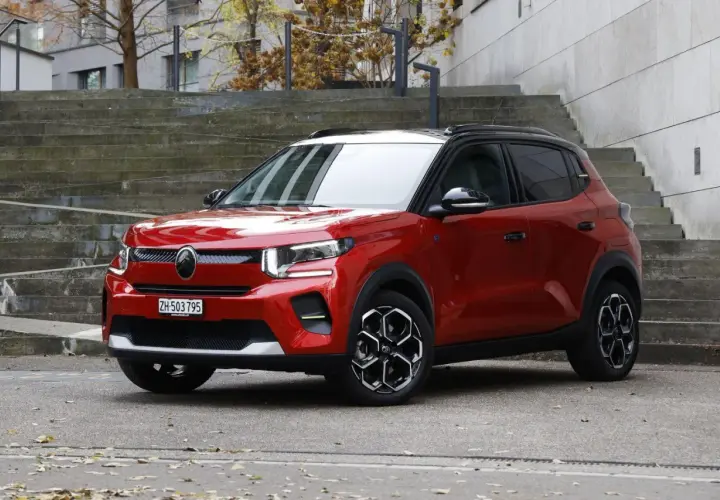 Czerwony Citroen EC3 z czarnym dachem stoi na tle betonowych schodów.
