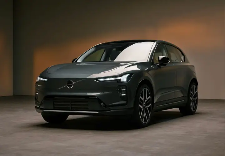 Nowoczesny, ciemnoszary Volvo EX60 z charakterystycznymi światłami LED stoi na betonowej podłodze.