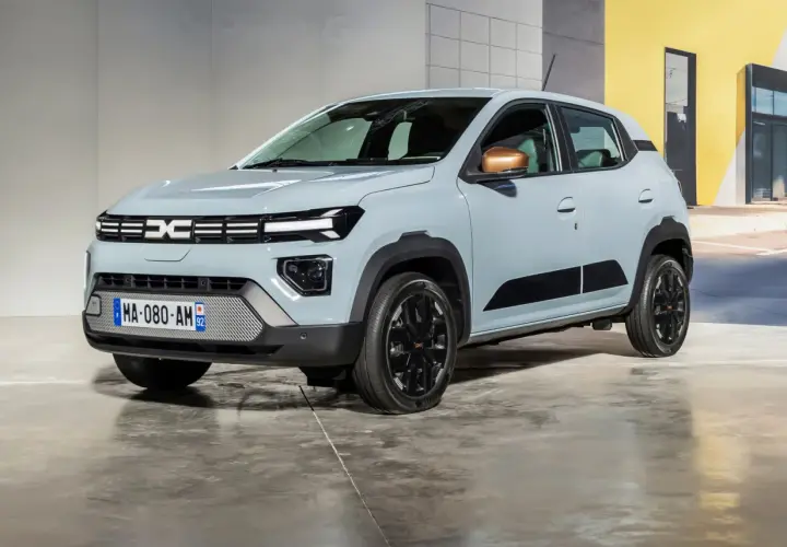 Nowa Dacia Spring w jasnoszarym kolorze, z czarnymi akcentami i miedzianymi lusterkami, prezentuje się nowocześnie.