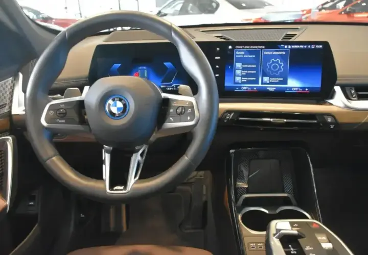 Wnętrze BMW X1 z nowoczesnym ekranem i kierownicą. Sprawdź aktualną bmw x1 cena i wyposażenie.