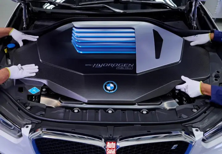 Ręce w białych rękawiczkach montują osłonę silnika BMW i Hydrogen Fuel Cell.