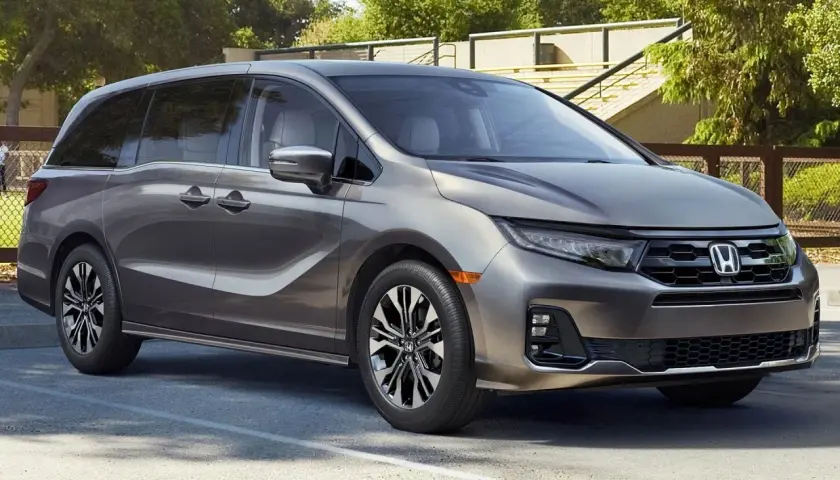 Elegancka, szara Honda Odyssey, model hybryda, zaparkowana na zewnątrz.