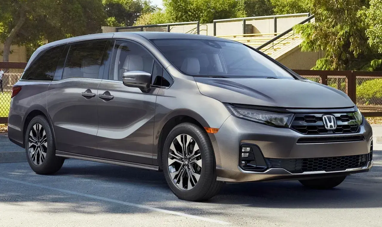Elegancka, szara Honda Odyssey, model hybryda, zaparkowana na zewnątrz.