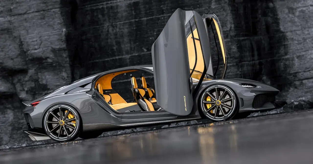 Szary Koenigsegg Gemera z otwartymi drzwiami i żółtym wnętrzem. Poznaj Koenigsegg Gemera cena i możliwości tego cudu techniki.