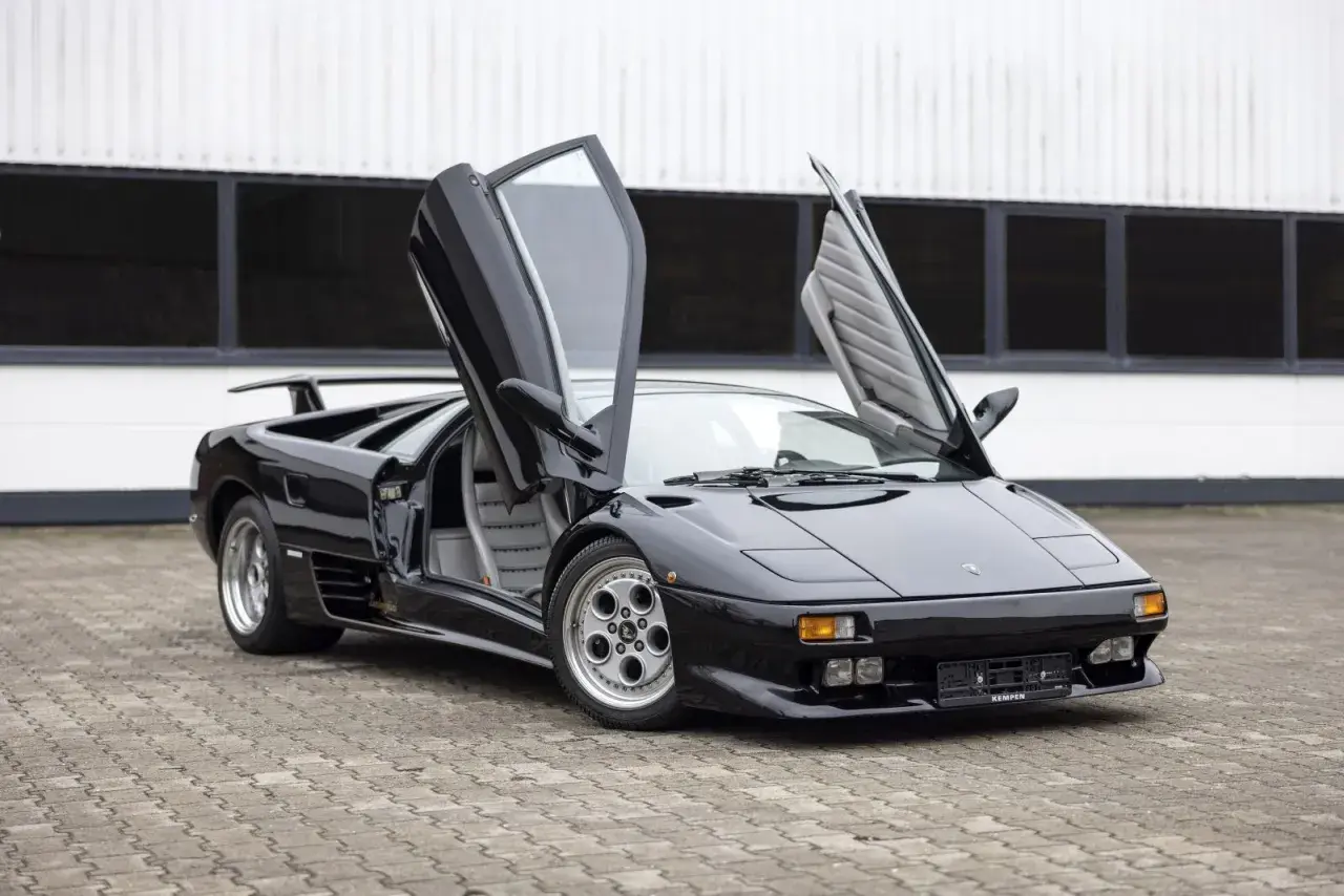 Czarny Lamborghini Diablo z otwartymi drzwiami, klasyk, którego lamborghini diablo cena budzi podziw.