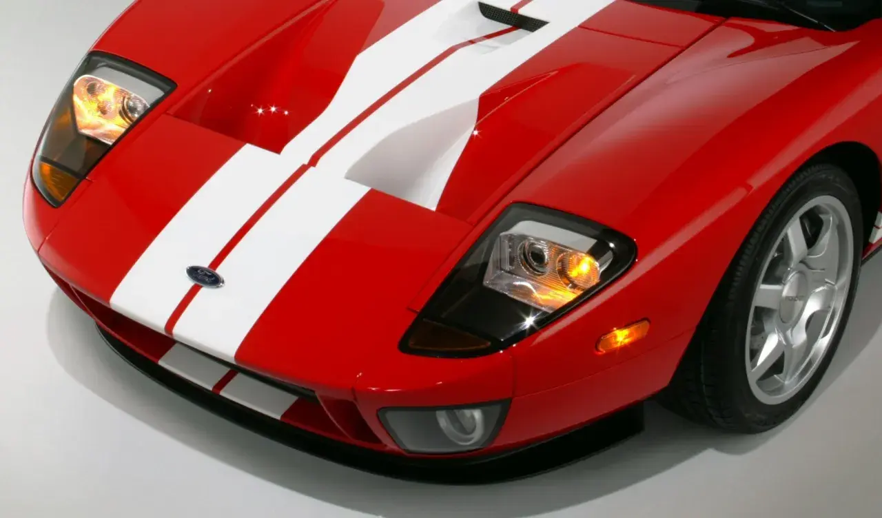Czerwony Ford GT z białymi pasami, sportowy wygląd. Zastanawiasz się nad ford gt cena?