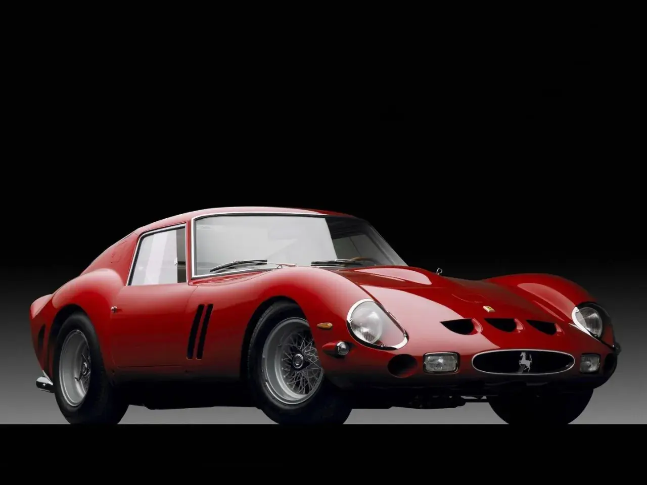 Czerwone Ferrari 250 GTO, ikona motoryzacji. Jego cena na aukcjach osiąga astronomiczne kwoty, świadcząc o legendarnym statusie.