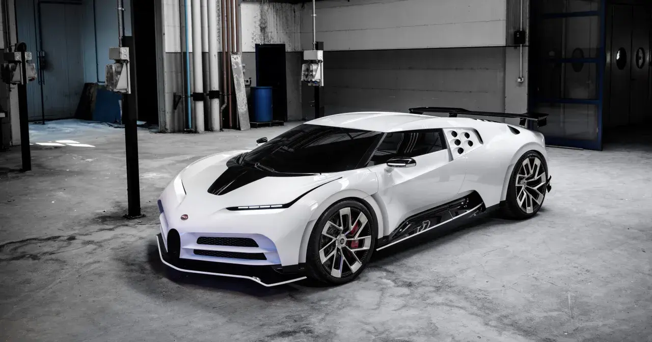 Biały Bugatti Centodieci z czarnym pasem na masce, stojący w garażu. Jego cena jest astronomiczna, ale to dzieło sztuki motoryzacyjnej.