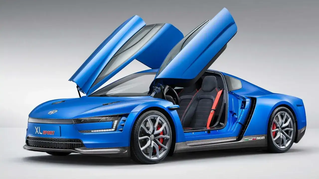 Niebieski Volkswagen XL Sport z podniesionymi drzwiami, sportowe fotele z czerwonymi pasami.