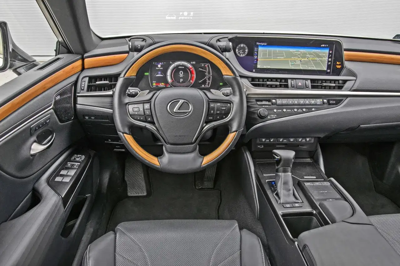 Wnętrze Lexusa ES z drewnianymi akcentami i ekranem nawigacji. Sprawdź aktualną lexus es cena i wyposażenie.