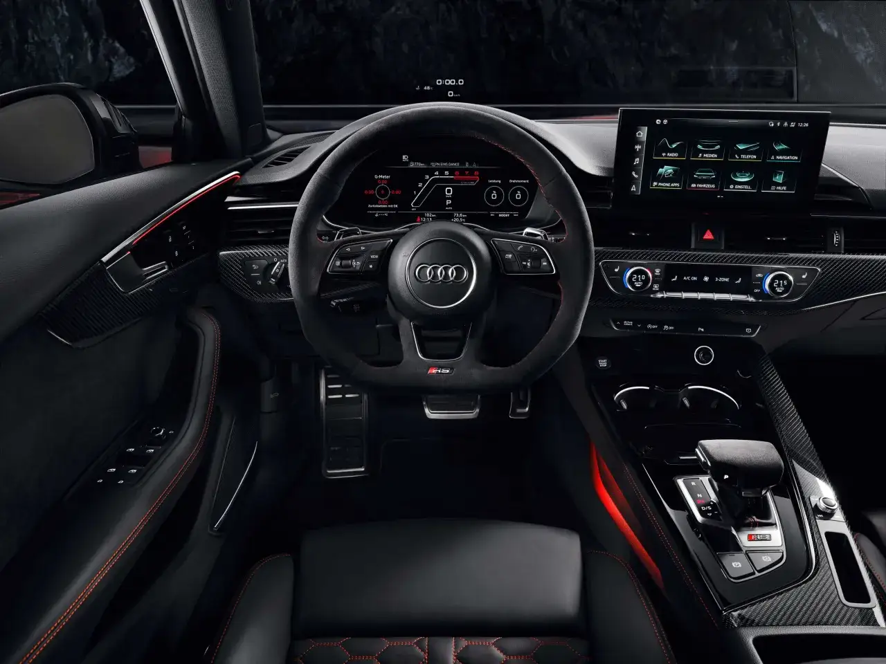 Wnętrze Audi RS4 z cyfrowymi zegarami i ekranem multimedialnym. Czerwone akcenty i sportowa kierownica podkreślają charakter. Sprawdź audi rs4 cena!