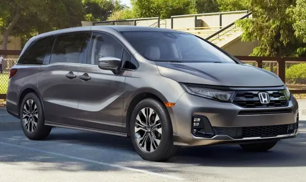 Elegancka, szara Honda Odyssey, model hybryda, zaparkowana na zewnątrz.
