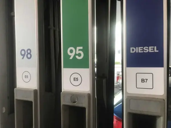 Kolumna z oznaczeniem diesla na stacji paliw, obok dystrybutorów 98 i 95.
