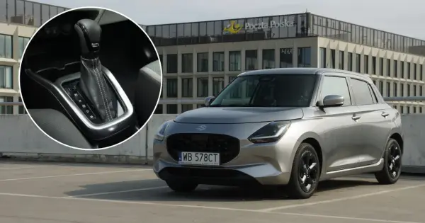 Srebrny Suzuki Swift Hybrid na parkingu przed budynkiem Poczty Polskiej. Widoczny detal dźwigni zmiany biegów.